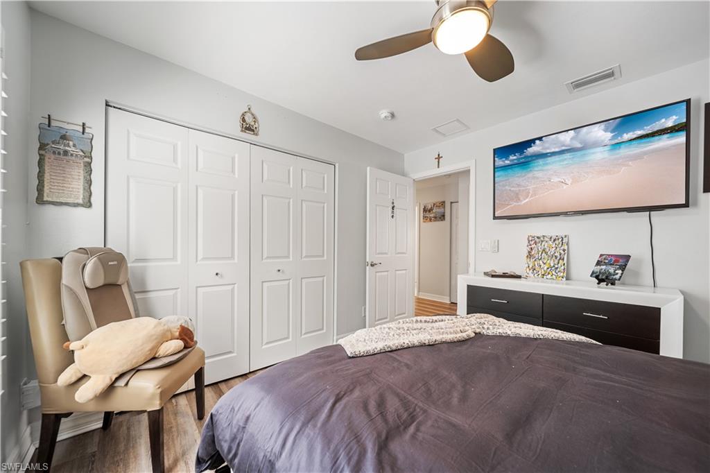 1638 Triangle Palm Terrace Naples, FL 34119 - Photo 12 of 21 Bedroom with a closet, wood finished floors, and a ceiling fan