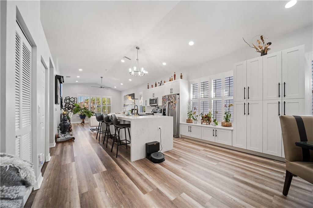 1638 Triangle Palm Terrace Naples, FL 34119 - Photo 6 of 21 Kitchen with recessed lighting, a chandelier, a center island with sink, appliances with stainless steel finishes, and light wood-style floors