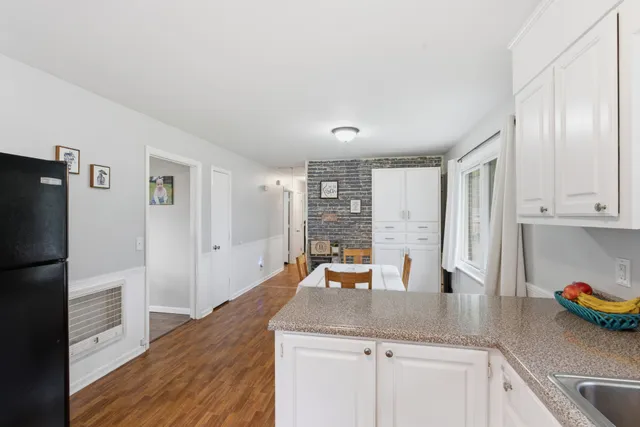 a kitchen with stainless steel appliances wooden floor and large windows