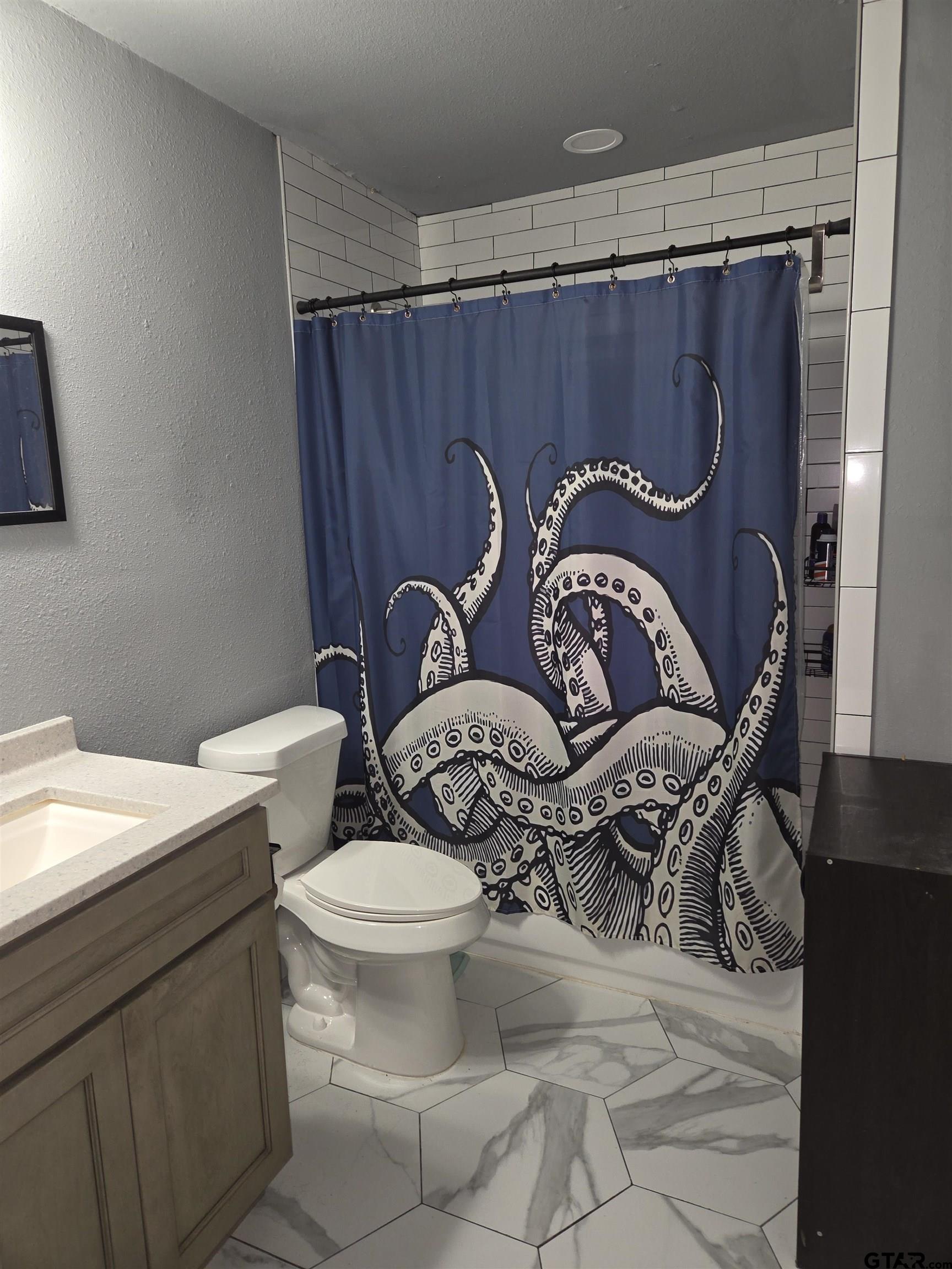 124 Foscue Street Sulphur Springs, TX 75482 - Photo 5 of 8 a bathroom with a toilet a sink and a mirror