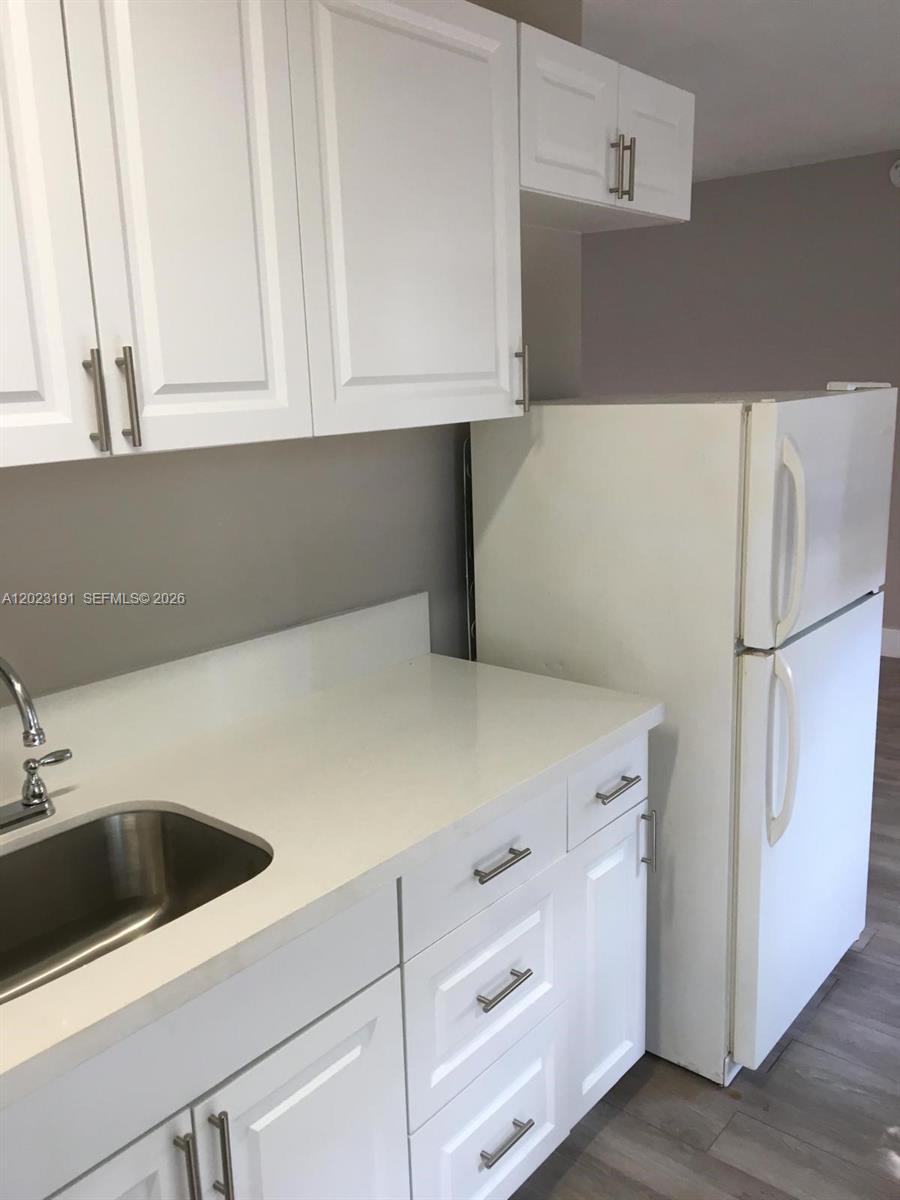 520 Southwest 4th Street, Unit 5 Miami, FL 33130 - Photo 8 of 11 a kitchen with white cabinets and white appliances