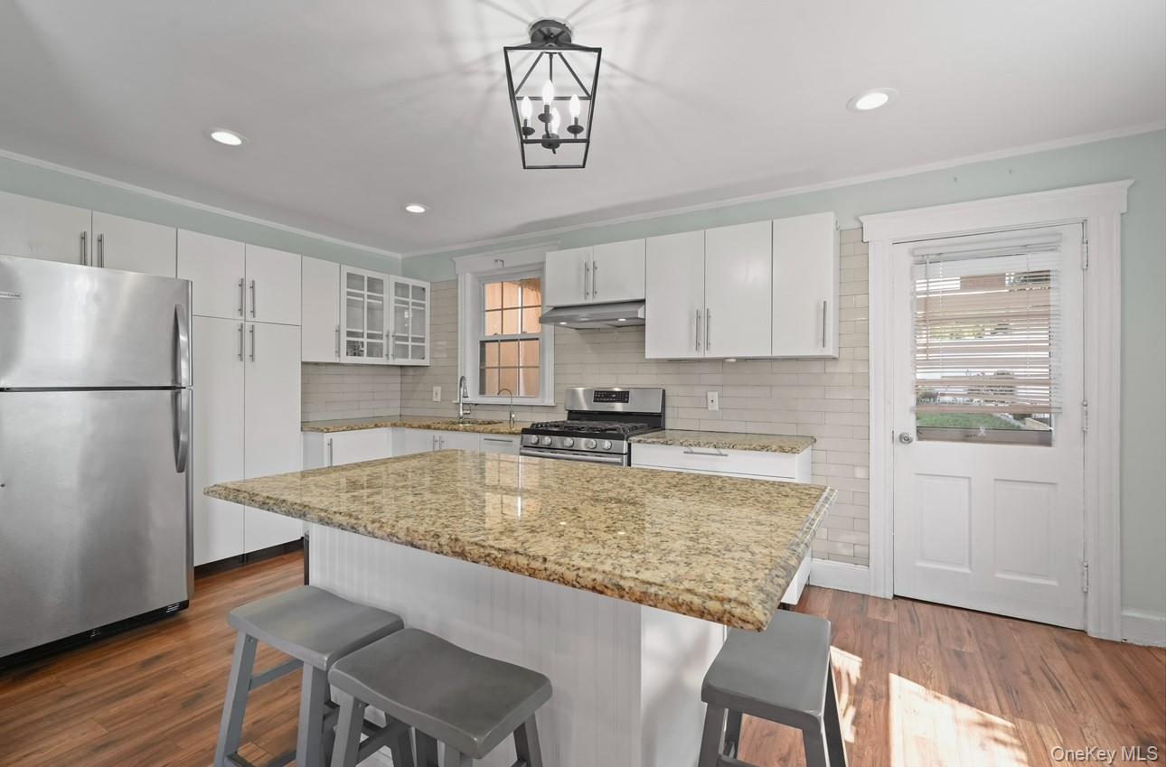 17 Edgar Place Port Chester, NY 10573 - Photo 7 of 18 Kitchen featuring stainless steel appliances, a breakfast bar area, dark wood-style floors, tasteful backsplash, and recessed lighting
