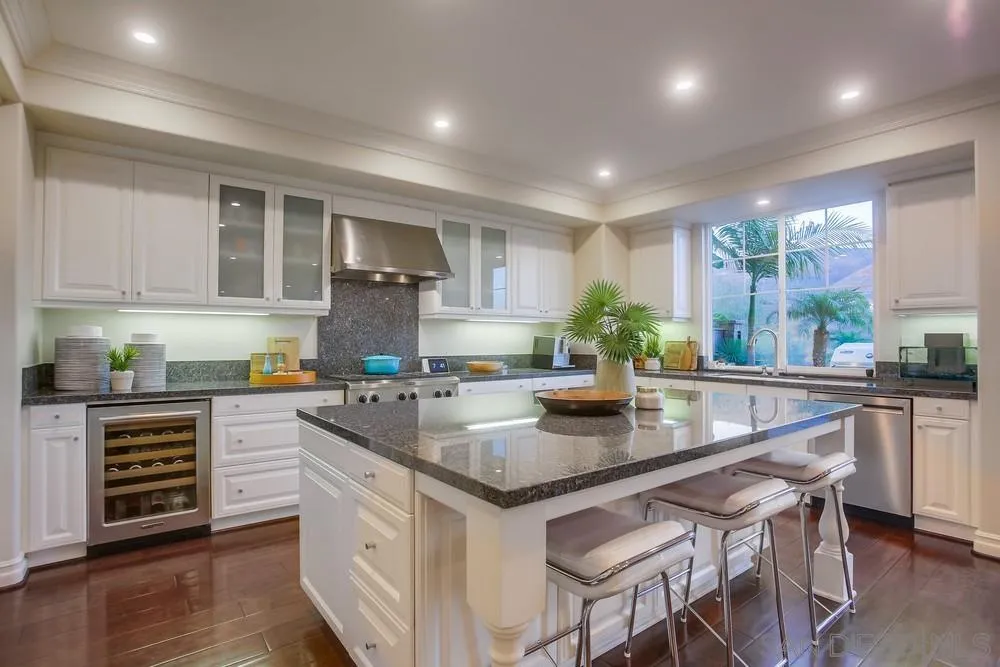 a kitchen with a sink a counter space appliances and cabinets