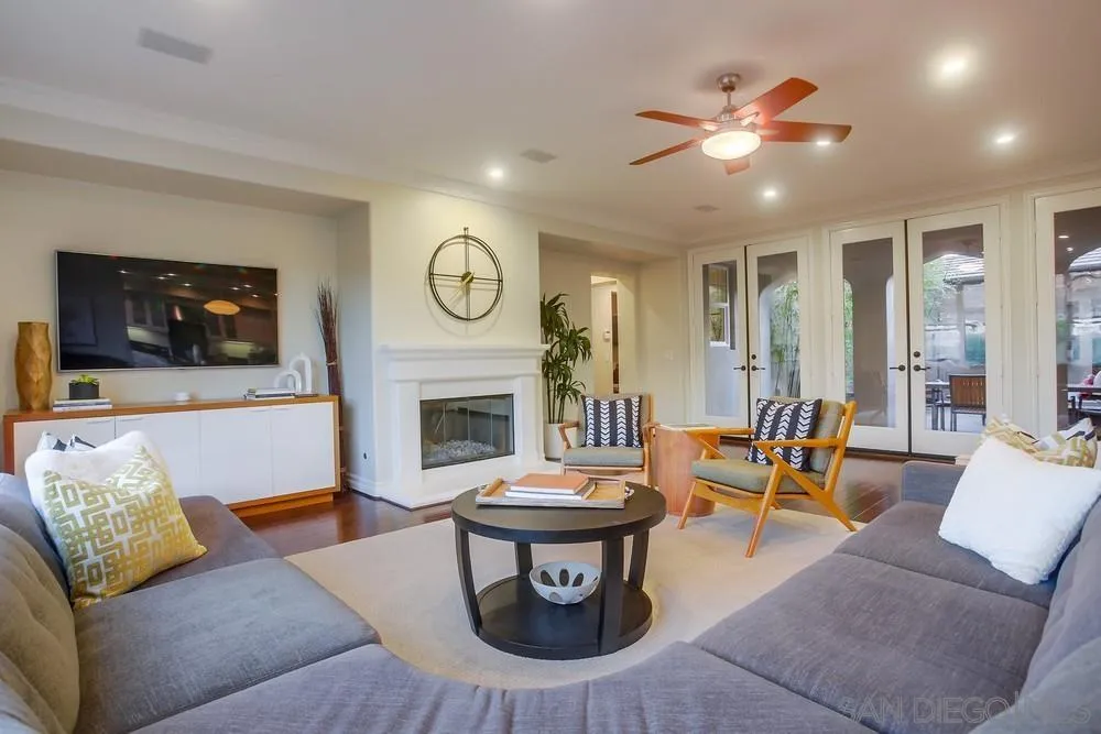 7535 Circulo Sequoia Carlsbad, CA 92009 - Photo 13 of 57 a living room with furniture a clock and a fireplace
