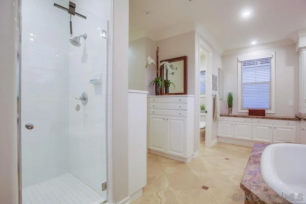 7535 Circulo Sequoia Carlsbad, CA 92009 - Photo 31 of 57 a bathroom with a tub shower and mirror
