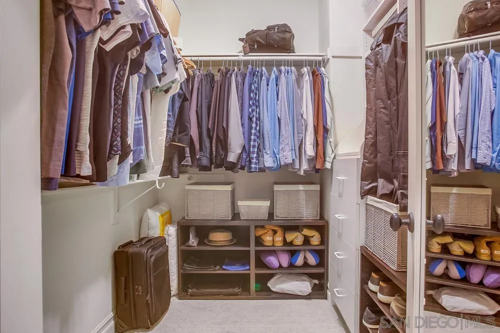 7535 Circulo Sequoia Carlsbad, CA 92009 - Photo 36 of 57 a view of walk in closet with clothes and shoes