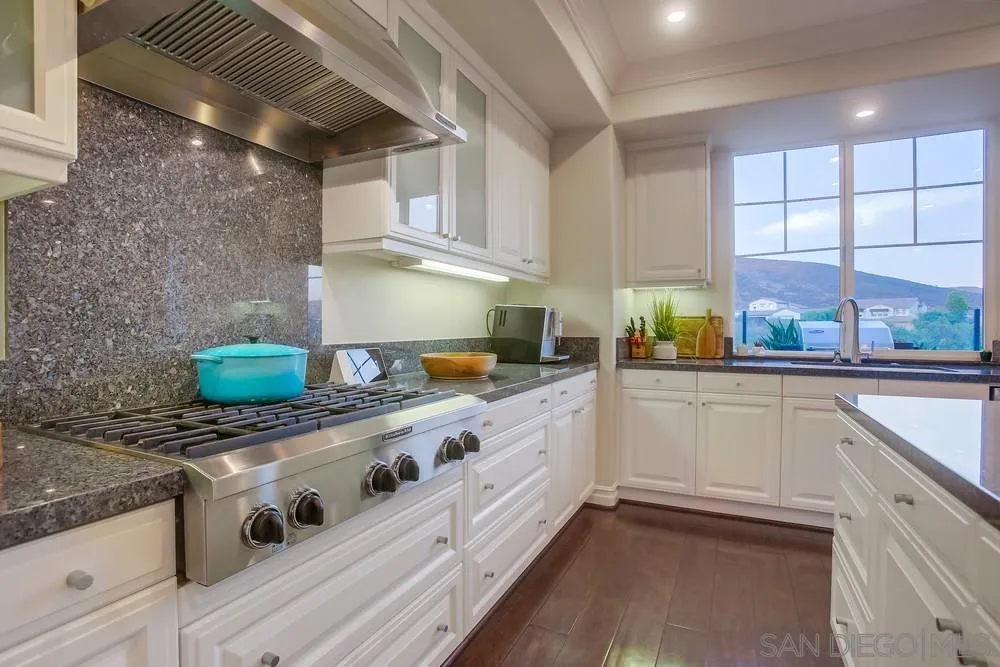 7535 Circulo Sequoia Carlsbad, CA 92009 - Photo 6 of 57 a kitchen with stainless steel appliances granite countertop a sink a stove and a refrigerator