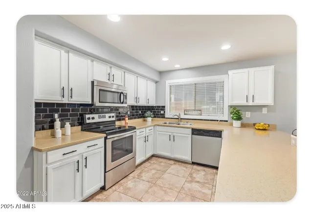 a kitchen with granite countertop white cabinets and white appliances