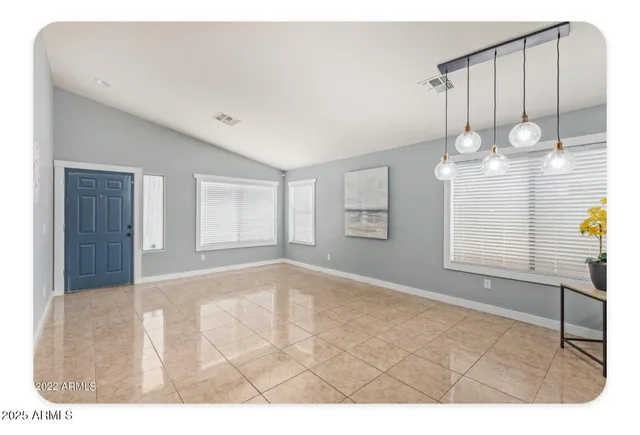 a view of an empty room with wooden floor and windows