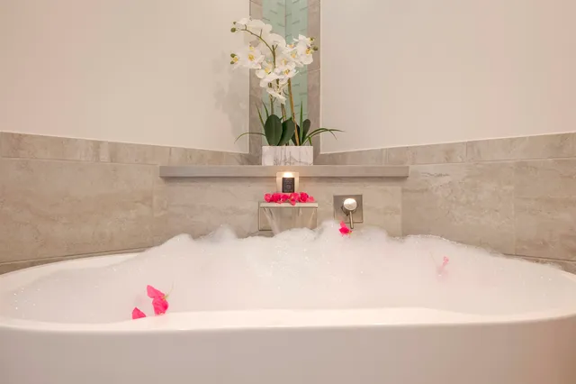 a bathroom with a tub shower and sink