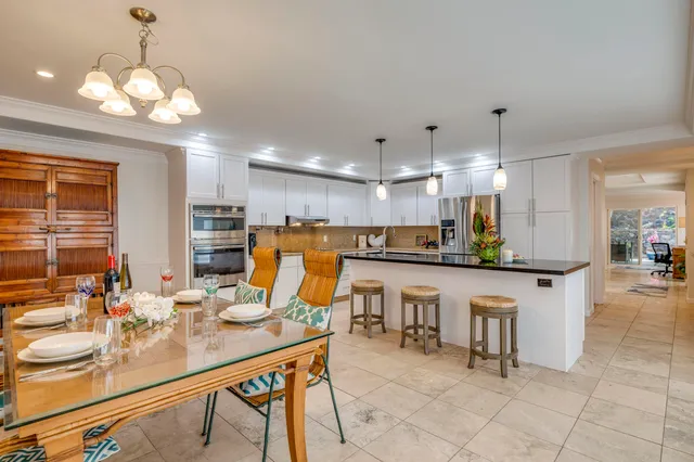 a kitchen with stainless steel appliances granite countertop a sink a stove a microwave a island with wooden cabinets