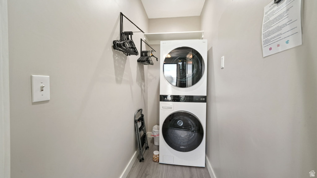 1364 Still Water Drive, Unit R2012 Heber City, UT 84032 - Photo 21 of 30 Dedicated laundry area featuring a stacked washer and dryer, a built-in hanging rod, overhead shelving, and wood-finish flooring