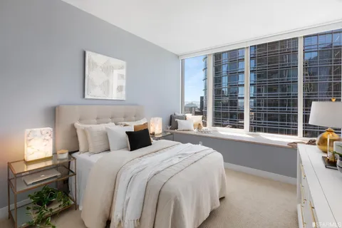 a bedroom with a bed and a large window