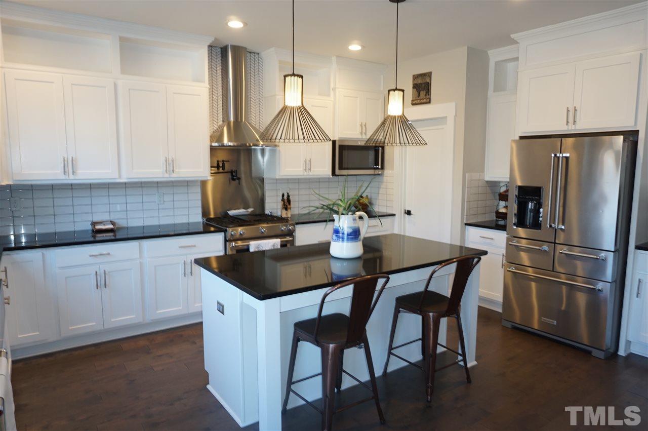1720 Chestnut Falls Road Wendell, NC 27591 - Photo 4 of 30 Chef's kitchen! Cabinets have been extended to ceiling. Upgrades include: LED can lights, light fixtures, stainless steel range hood, back splash by range/hood, KitchenAid appliances and pot filler.