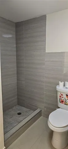 a bathroom with a toilet and a shower