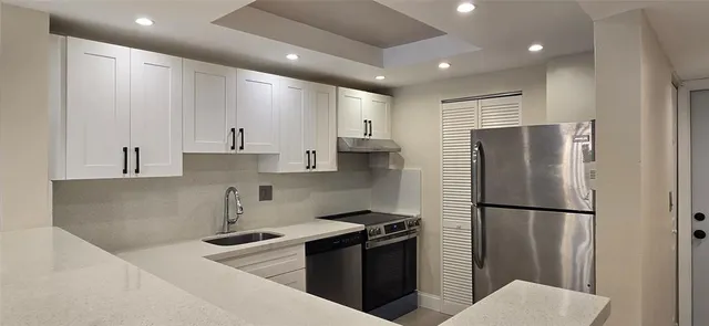 a kitchen with stainless steel appliances granite countertop a refrigerator a sink and a stove