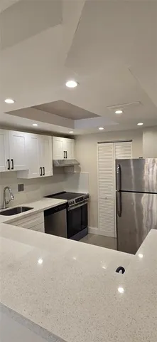 a large kitchen with stainless steel appliances a large counter top