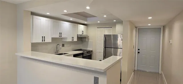 a kitchen with stainless steel appliances a refrigerator sink and microwave