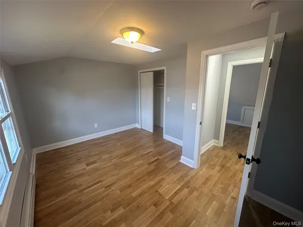 wooden floor in an empty room with a bathroom