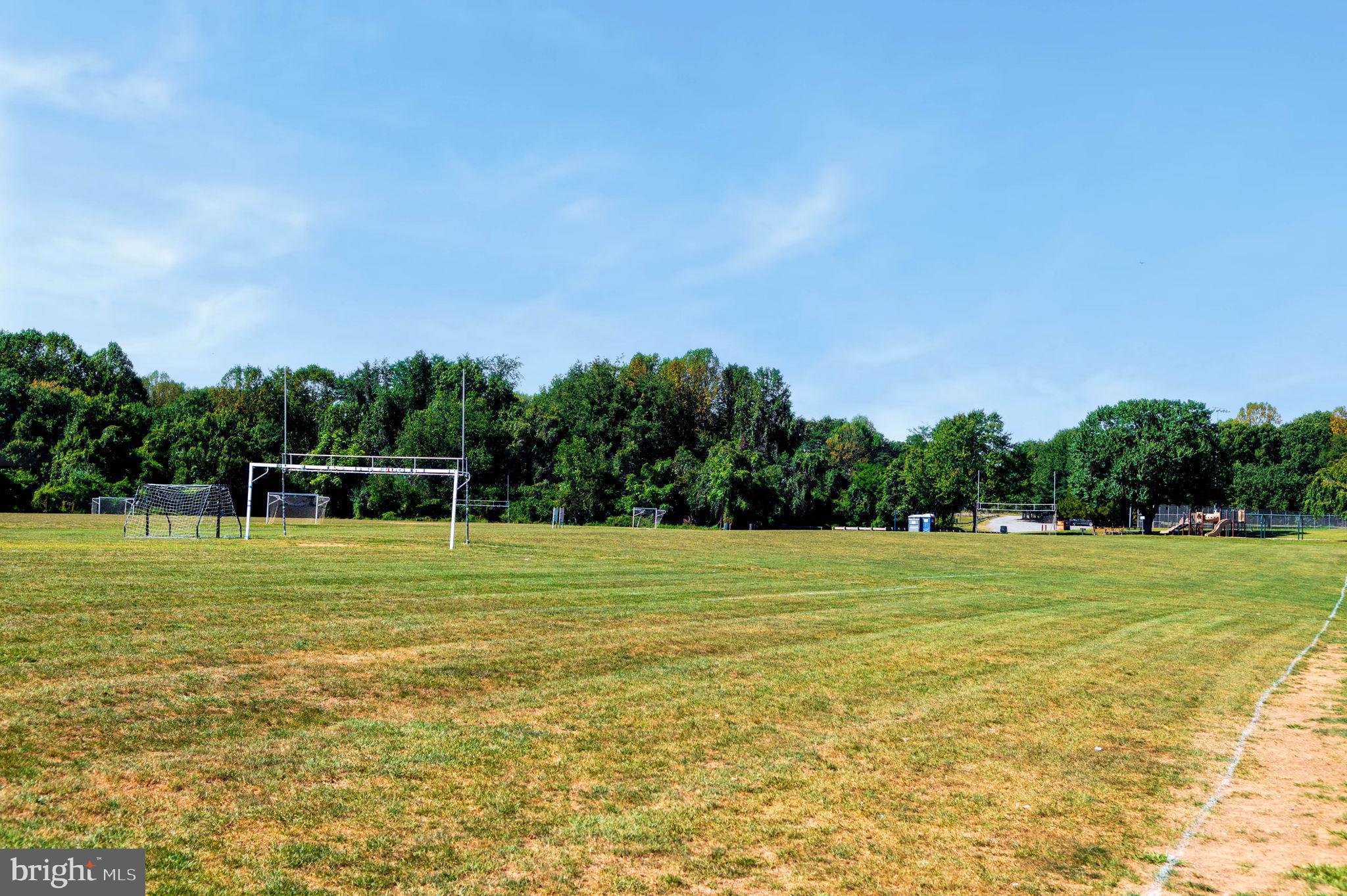 1443 Northgate Square, Unit 22B Reston, VA 20190 - Photo 41 of 42 a view of a grassy field with trees in the background