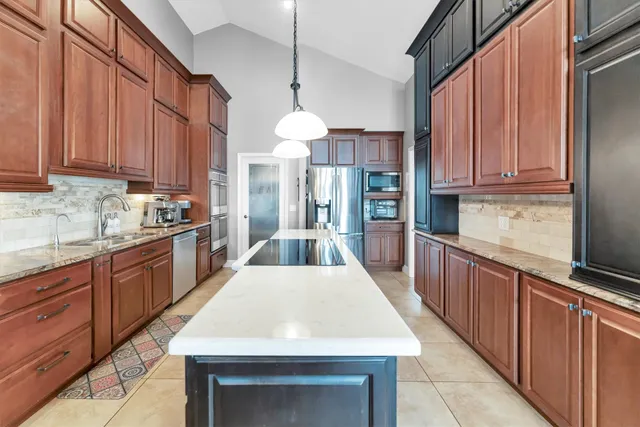 a kitchen with granite countertop stainless steel appliances and refrigerator
