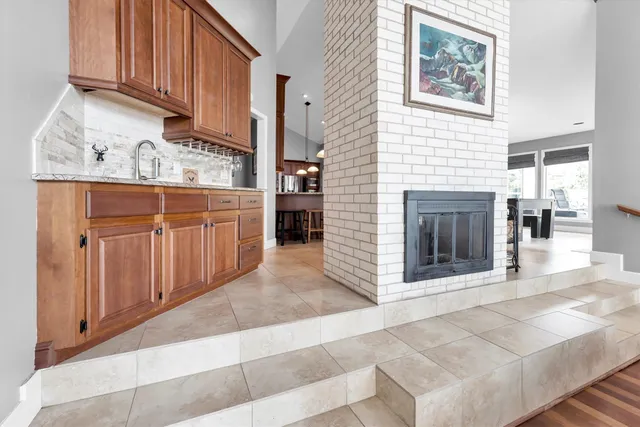 a living room with furniture fireplace and a large window