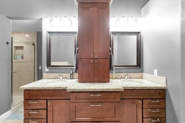 a bedroom with a bed a table and windows