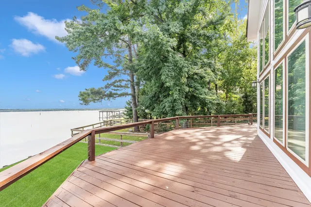 a view of a patio with a dining table chairs and wooden floor