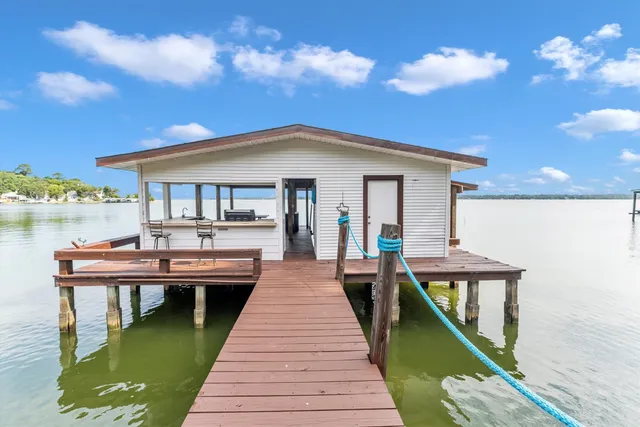 a view of a swimming pool with lawn chairs and a big yard