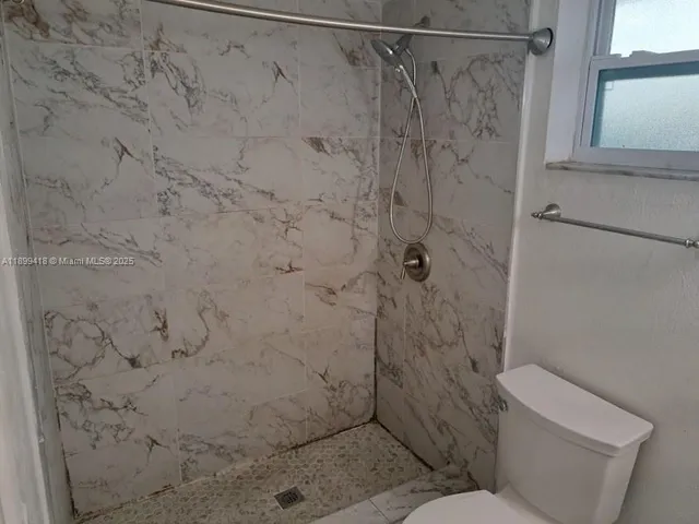 a bathroom with a toilet and shower