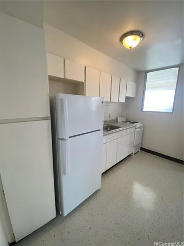 a kitchen with a refrigerator and a more cabinets