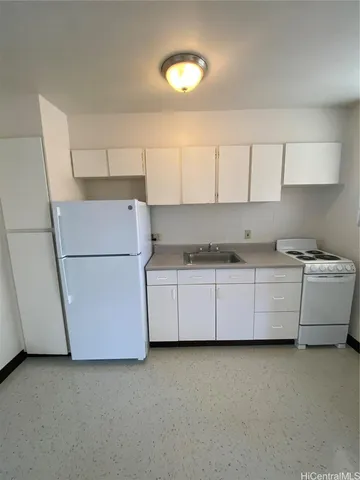 a kitchen with cabinets and a refrigerator