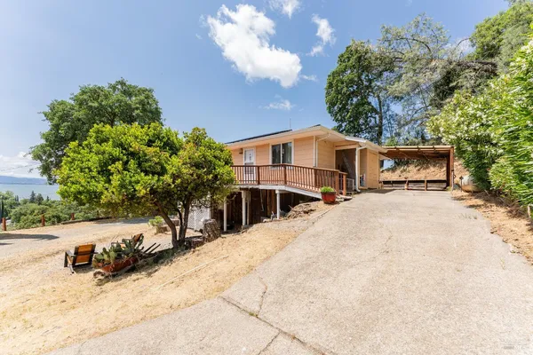 a view of house with yard and trees in the background