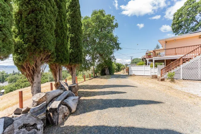 an aerial view of a house with a yard and large trees