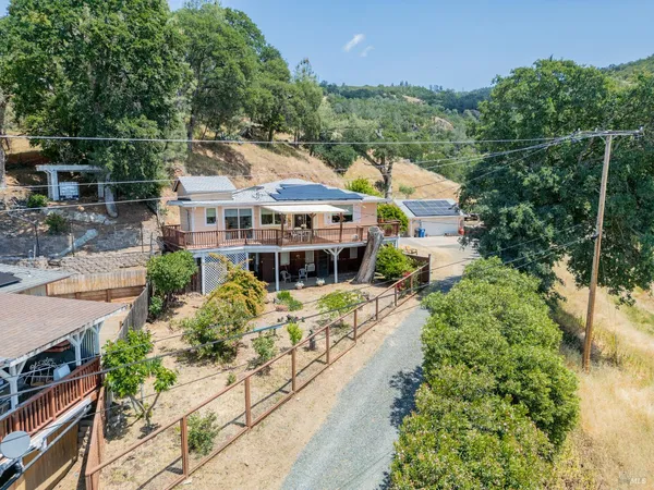 an aerial view of a house with a yard and greenery space