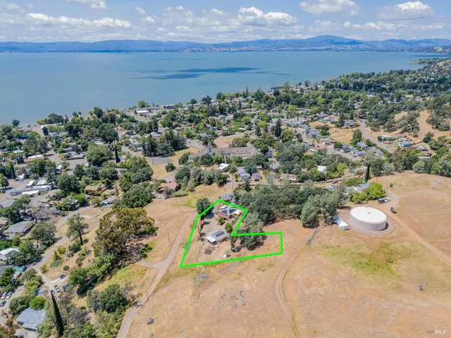 an aerial view of a house with a yard and trees