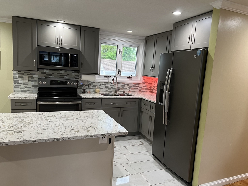 18 Shirley Road Springfield, MA 01109 - Photo 22 of 39 a kitchen with stainless steel appliances granite countertop a refrigerator a stove a sink and a microwave