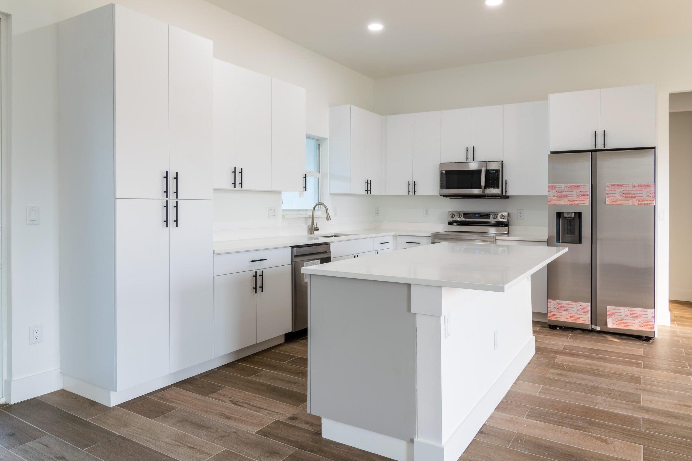 10625 Ayear Road Port Charlotte, FL 33981 - Photo 9 of 33 a kitchen with kitchen island a white cabinets and refrigerator