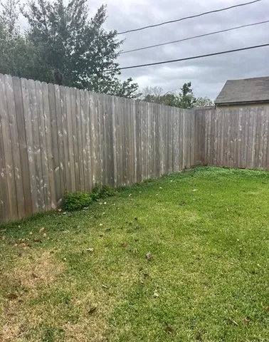 a view of backyard with wooden fence