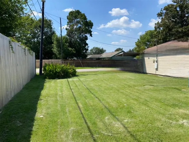 a view of yard with swimming pool and green space
