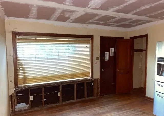 a view of a room with wooden floor and a large window