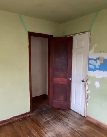 an empty room with wooden floor and closet