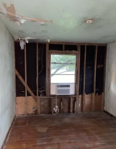 a view of a room with wooden floor and windows