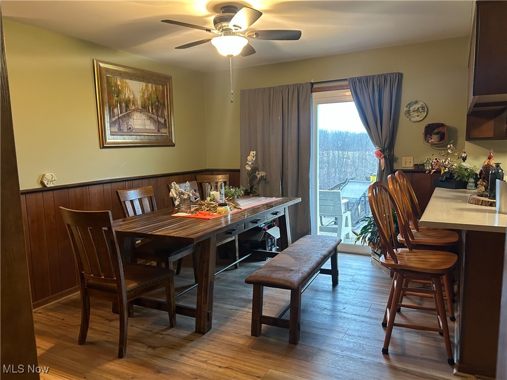 2242 South McCoy Ridge Road Stockport, OH 43787 - Photo 5 of 41 Dining room featuring light wood finished floors, wainscoting, and ceiling fan