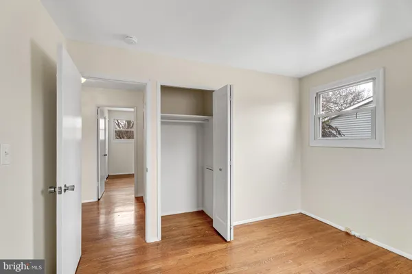 an empty room with wooden floor and a window