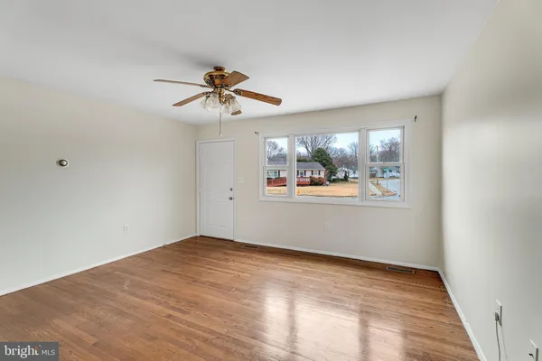 a view of empty room with wooden floor