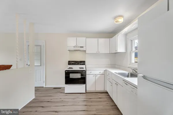 a kitchen with stainless steel appliances sink a stove and cabinets