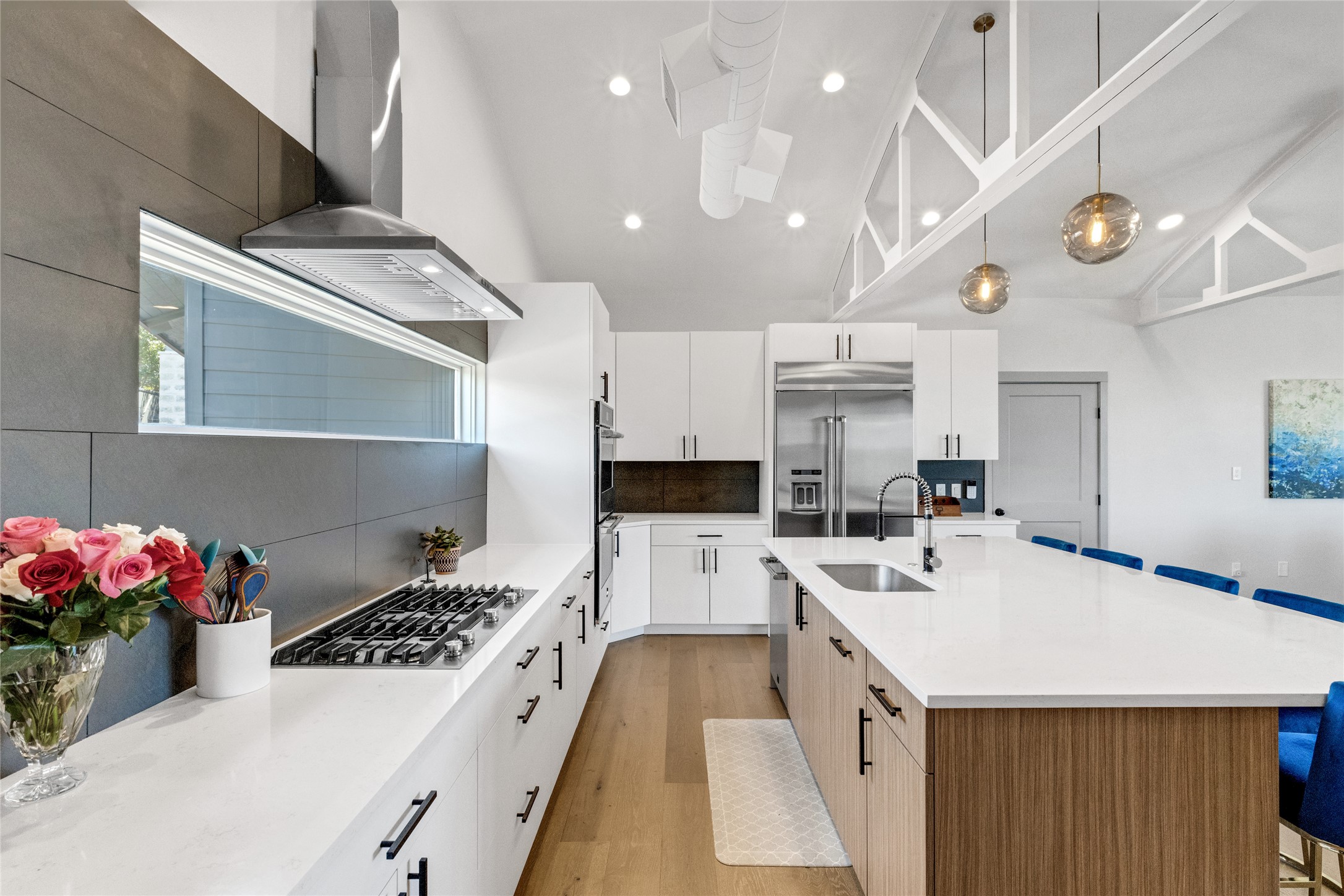 4227 Eck Lane Austin, TX 78734 - Photo 6 of 30 Kitchen featuring a kitchen breakfast bar, modern cabinets, white cabinets, decorative backsplash, and recessed lighting