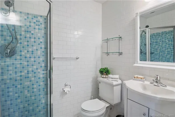 a bathroom with a sink a toilet and shower