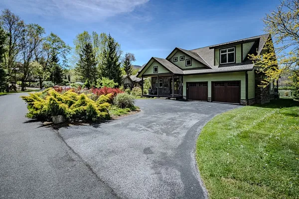 a front view of a house with a yard and a garage